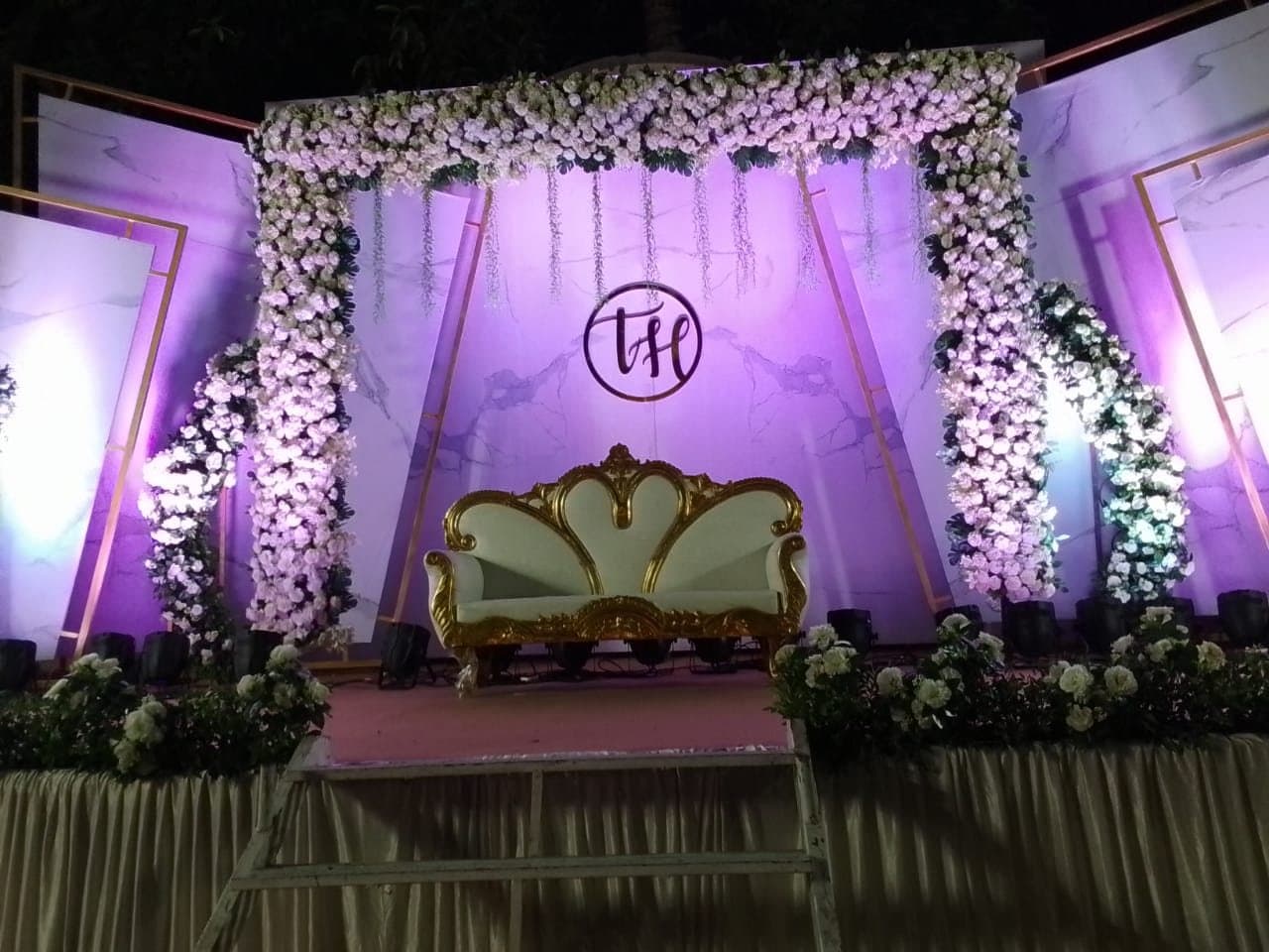 White floral wedding stage under purple light